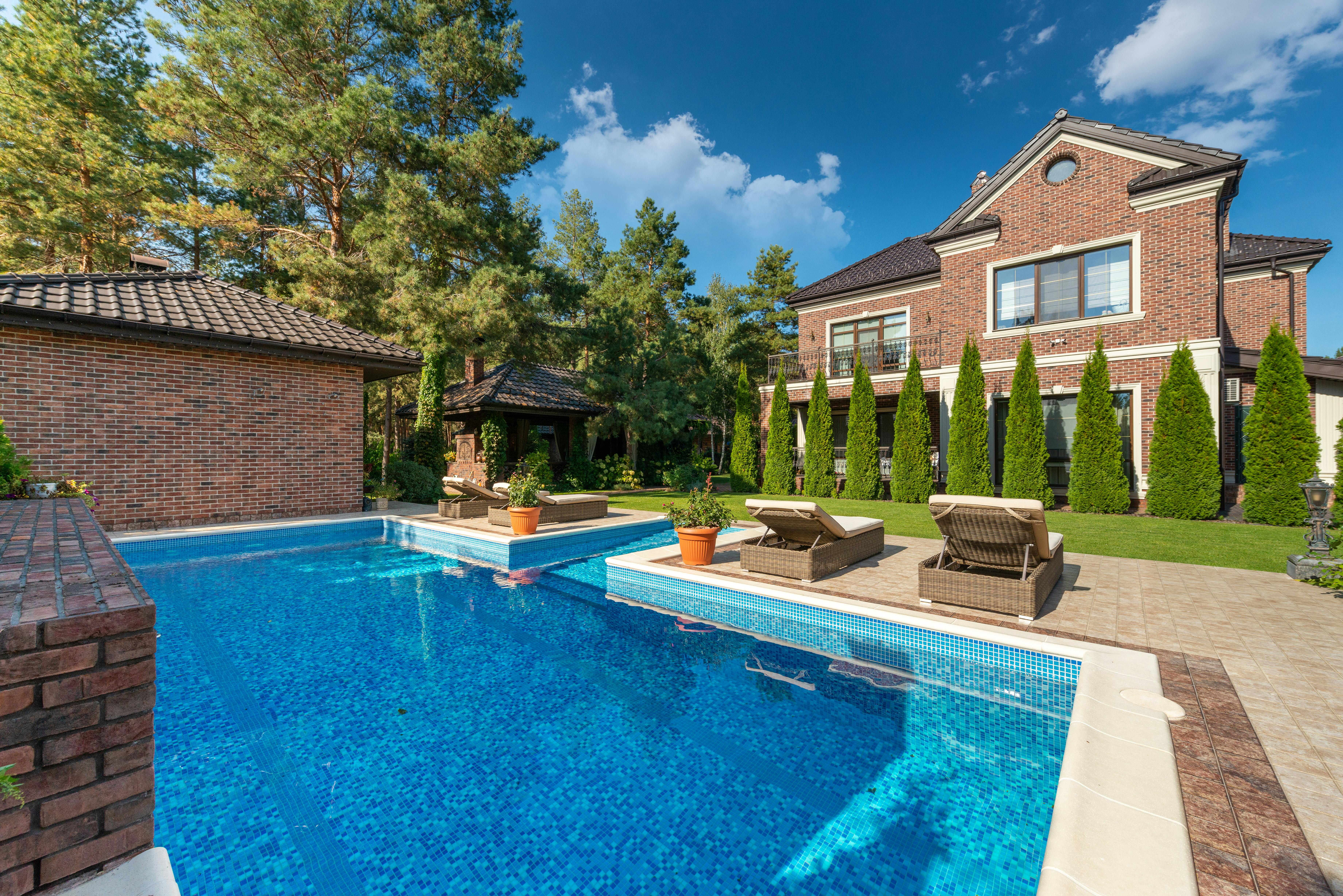 Färdigställd pool och uteplats vid ett hus